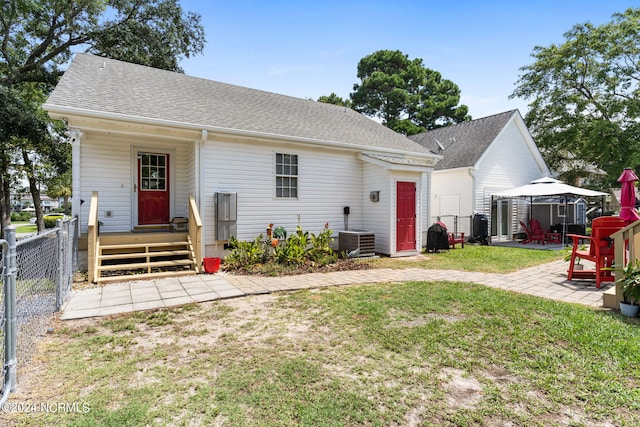 view of front of house featuring central AC unit, a gazebo, a patio area, and a front yard