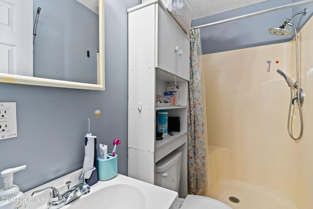 bathroom featuring a textured ceiling, toilet, and a shower with curtain