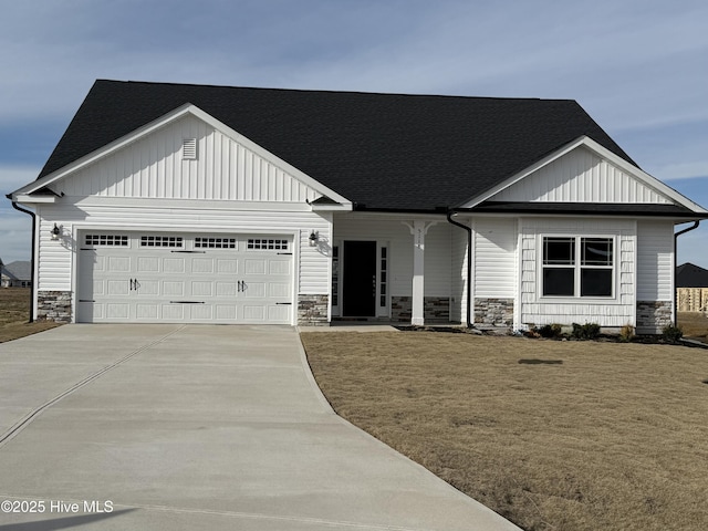 view of front of property with stone siding, concrete driveway, an attached garage, and a front yard