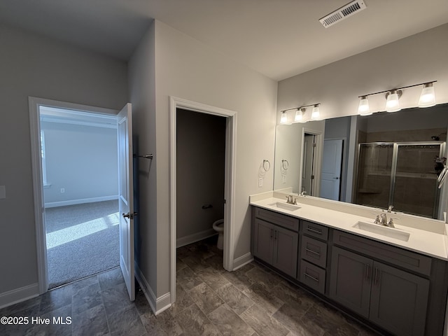 bathroom with double vanity, a sink, visible vents, and baseboards