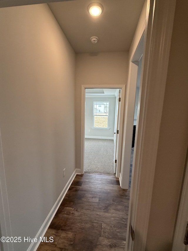 corridor with dark wood-style floors and baseboards