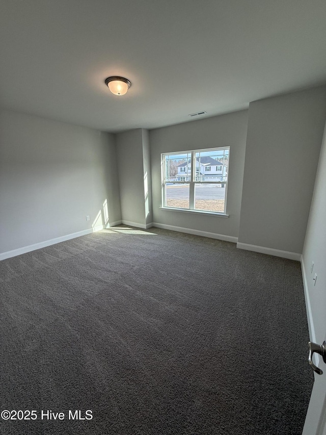 unfurnished room featuring carpet floors and baseboards