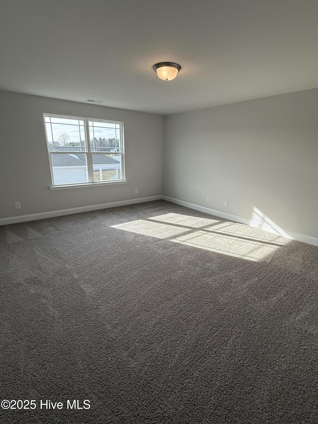 unfurnished room with baseboards and carpet flooring