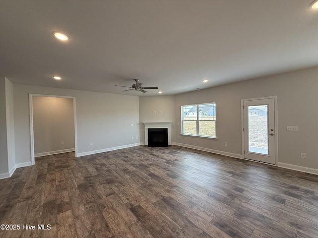 unfurnished living room with dark wood-type flooring, recessed lighting, a fireplace, and a ceiling fan