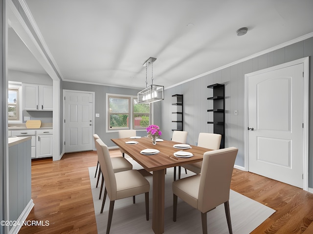 dining space with light hardwood / wood-style flooring and crown molding