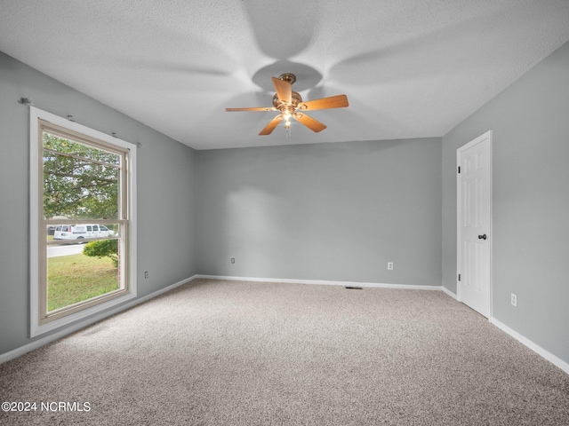 unfurnished room featuring a ceiling fan, carpet, a textured ceiling, and baseboards