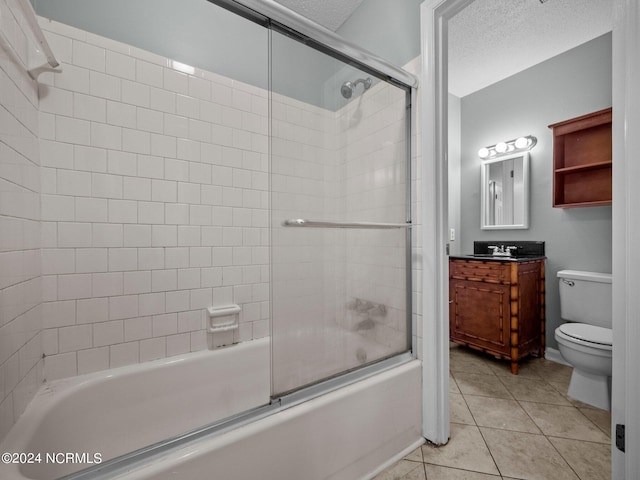 full bathroom with vanity, tile patterned floors, shower / bath combination with glass door, toilet, and a textured ceiling