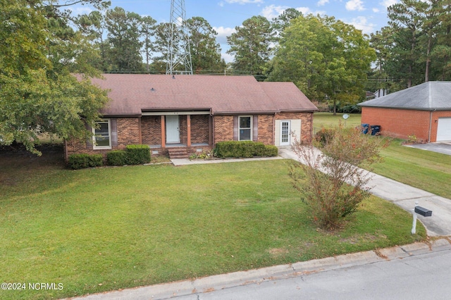 ranch-style house featuring brick siding, a front lawn, and a shingled roof