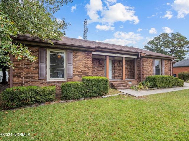 ranch-style home featuring a front yard and brick siding