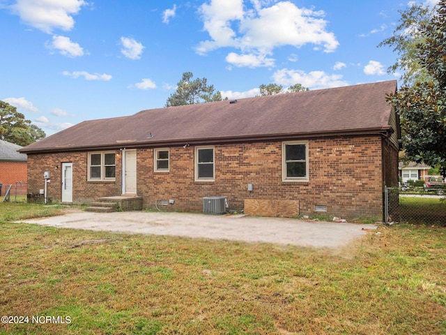 back of property with a patio area, brick siding, fence, and a lawn