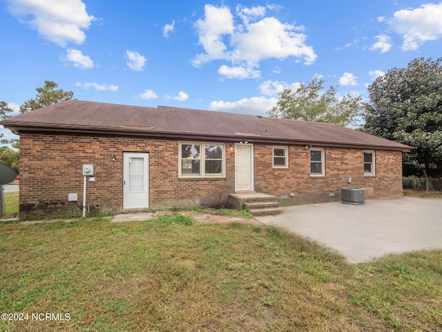 rear view of property featuring a yard, brick siding, crawl space, and a patio area