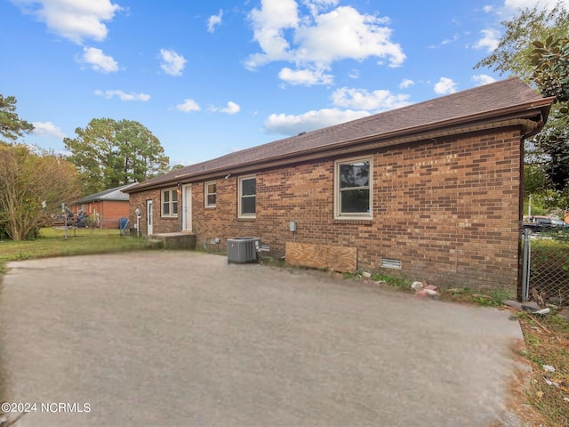 back of house featuring central AC, brick siding, a patio, and crawl space