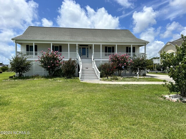 view of front of house featuring covered porch, roof with shingles, stairway, and a front yard