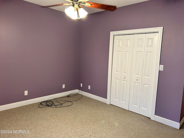 unfurnished bedroom featuring carpet floors, ceiling fan, and a closet