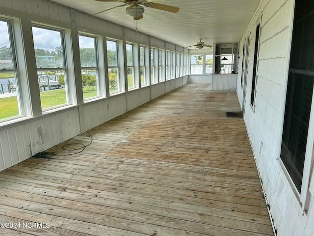 unfurnished sunroom featuring a healthy amount of sunlight and ceiling fan