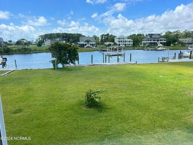 view of dock with a water view and a lawn