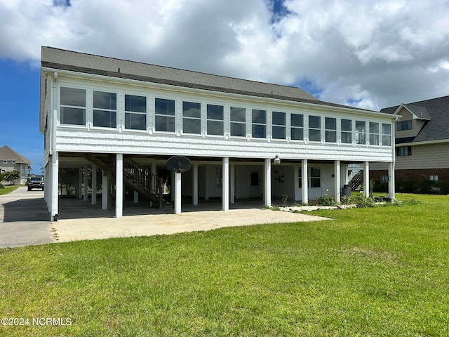 back of property with a carport and a lawn