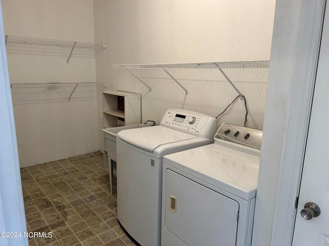 washroom featuring washing machine and dryer and dark tile patterned floors