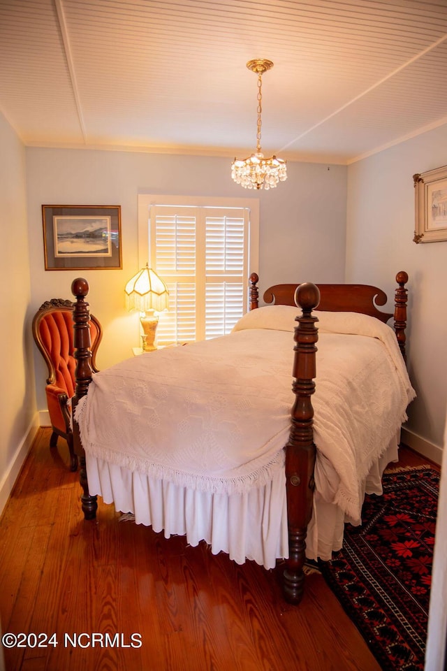 bedroom with an inviting chandelier and wood-type flooring