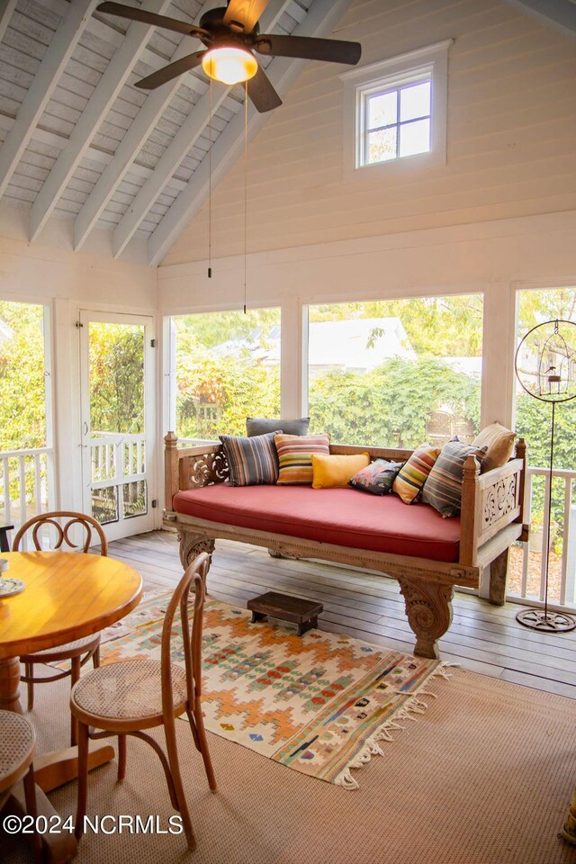 sunroom / solarium featuring ceiling fan and vaulted ceiling with beams