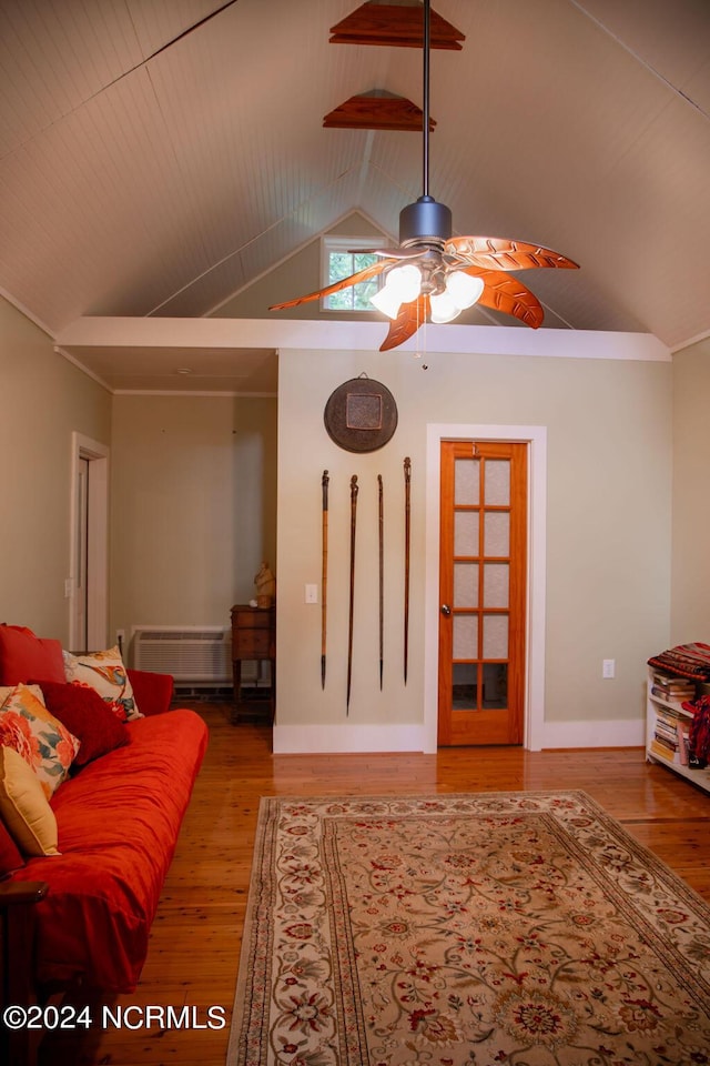 living room featuring lofted ceiling, hardwood / wood-style flooring, an AC wall unit, and ceiling fan