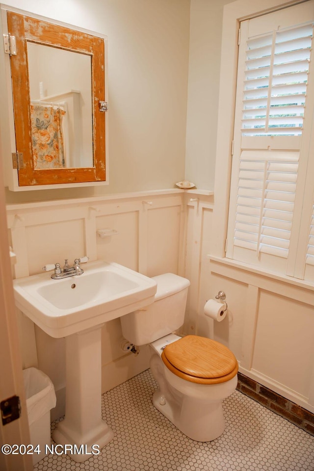 bathroom featuring toilet, tile patterned floors, and sink