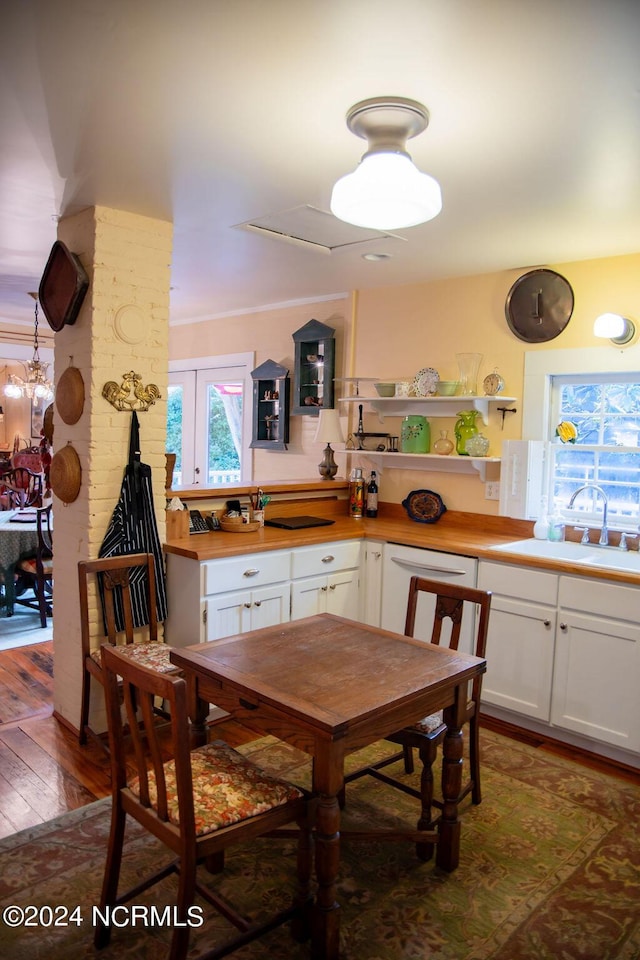 kitchen with sink, white cabinets, white dishwasher, hanging light fixtures, and dark hardwood / wood-style floors