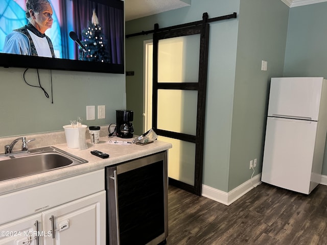 kitchen featuring sink, white cabinets, a barn door, beverage cooler, and white fridge