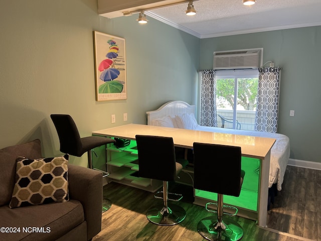 interior space with a wall mounted air conditioner, rail lighting, hardwood / wood-style floors, crown molding, and a textured ceiling