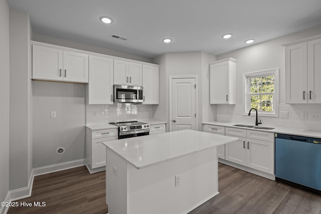kitchen featuring sink, white cabinetry, dark hardwood / wood-style flooring, a kitchen island, and stainless steel appliances