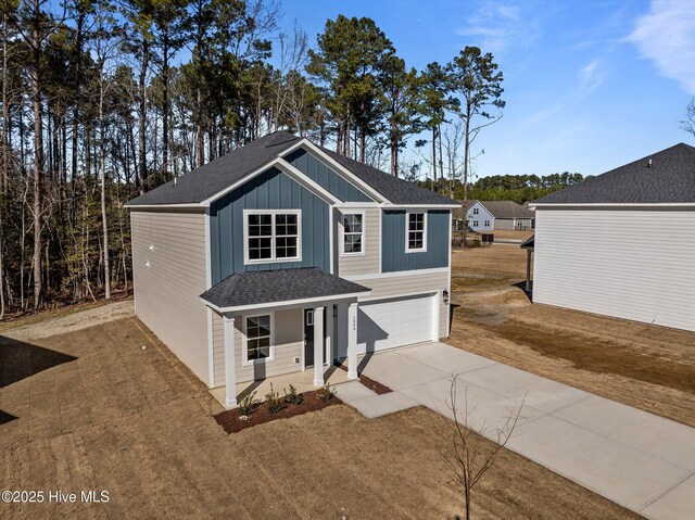 view of front of property with a garage, covered porch, and a front lawn