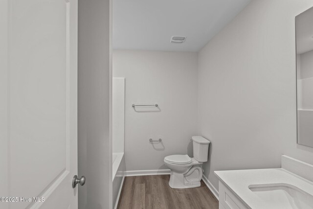bathroom with vanity, toilet, and hardwood / wood-style floors
