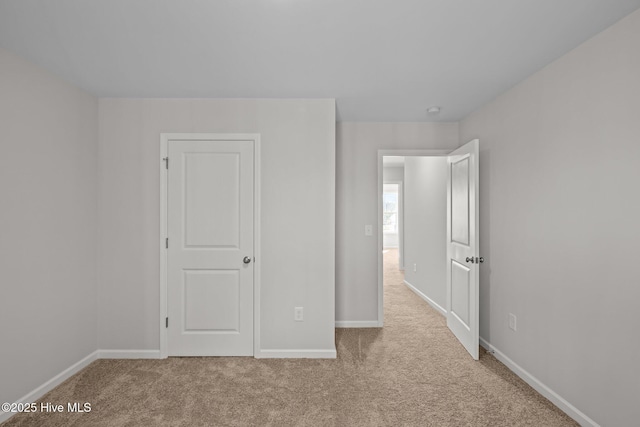 unfurnished bedroom featuring light carpet