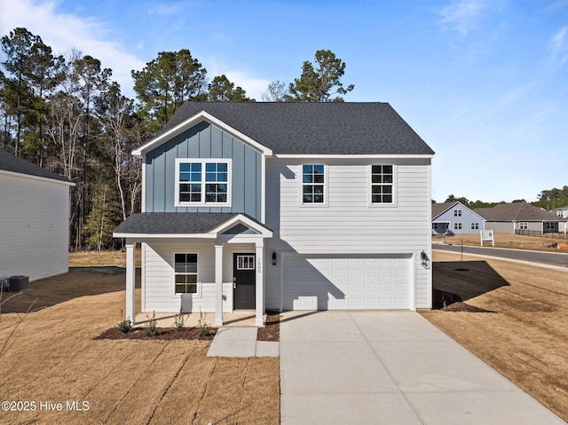 view of front of home with a garage, a front yard, covered porch, and central air condition unit