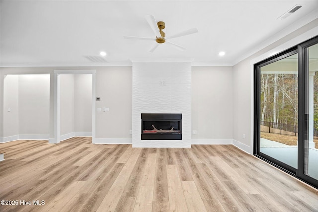 unfurnished living room with crown molding, a fireplace, ceiling fan, and light wood-type flooring