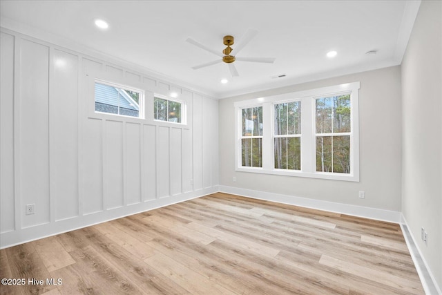 spare room with crown molding, ceiling fan, light hardwood / wood-style floors, and a wealth of natural light