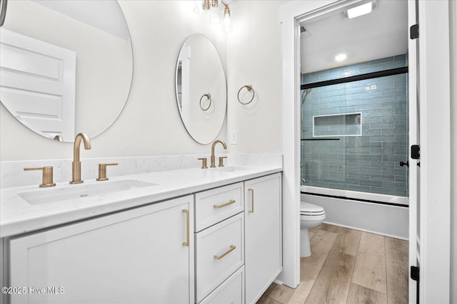 full bathroom featuring enclosed tub / shower combo, vanity, and toilet