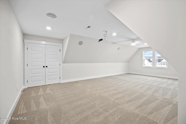 additional living space featuring light carpet and vaulted ceiling