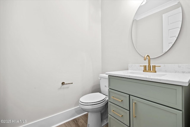 bathroom featuring hardwood / wood-style flooring, vanity, ornamental molding, and toilet