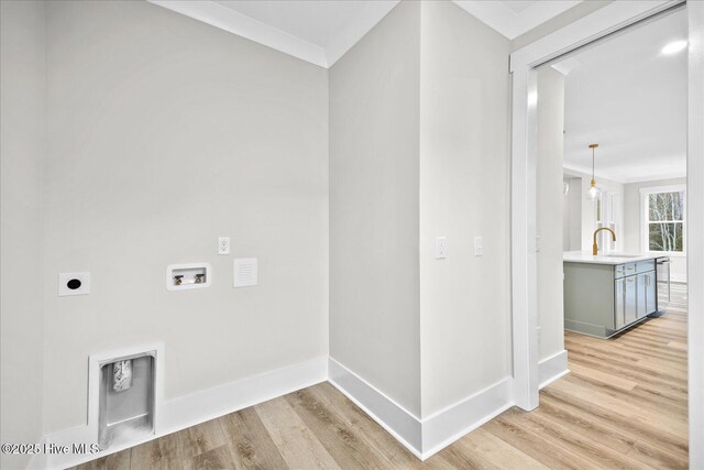 laundry area featuring sink, crown molding, light hardwood / wood-style flooring, hookup for a washing machine, and hookup for an electric dryer