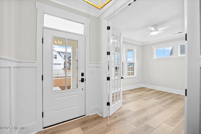 foyer with crown molding, ceiling fan, and light hardwood / wood-style flooring