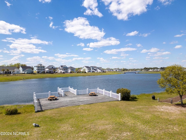 view of dock featuring a water view, a yard, and an outdoor fire pit