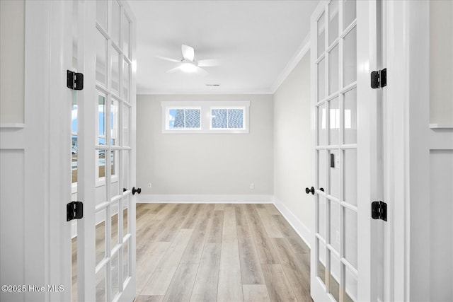 spare room featuring ornamental molding, light hardwood / wood-style flooring, a wealth of natural light, and french doors