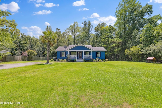 ranch-style house featuring covered porch and a front lawn