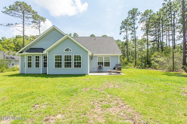 back of house featuring a lawn and a patio area