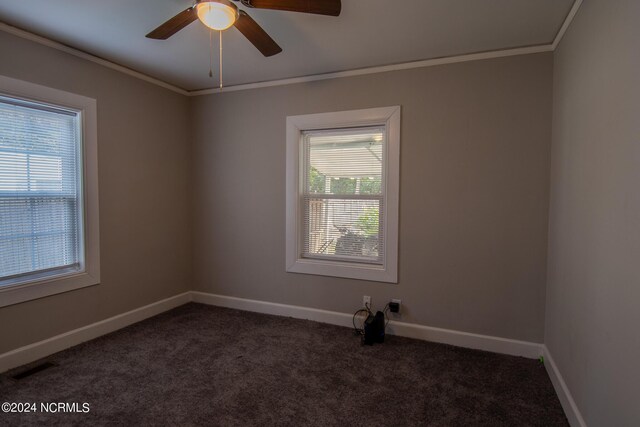 empty room with crown molding, ceiling fan, and carpet flooring