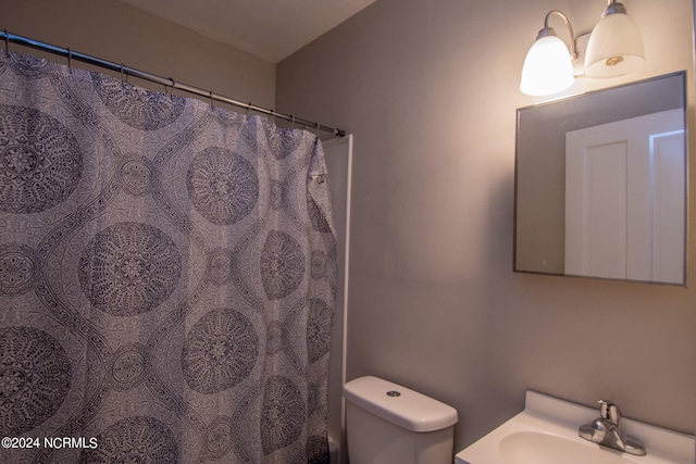 bathroom with a shower with curtain, toilet, and sink