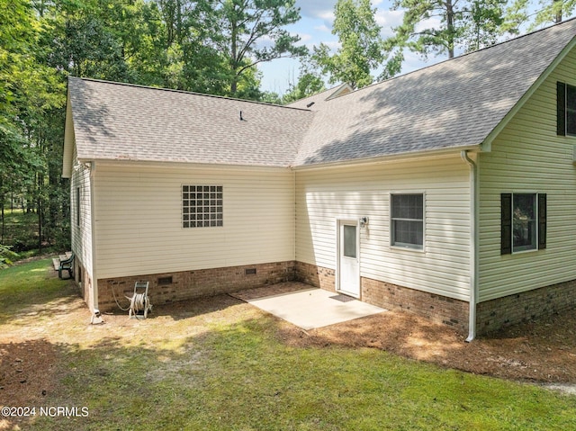 rear view of house with a lawn and a patio