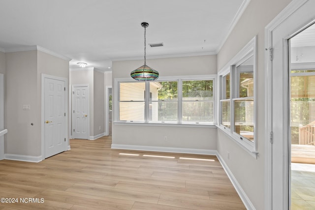 unfurnished dining area featuring light hardwood / wood-style flooring and ornamental molding