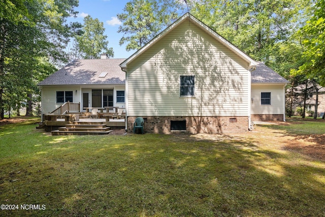 rear view of house featuring a wooden deck and a yard